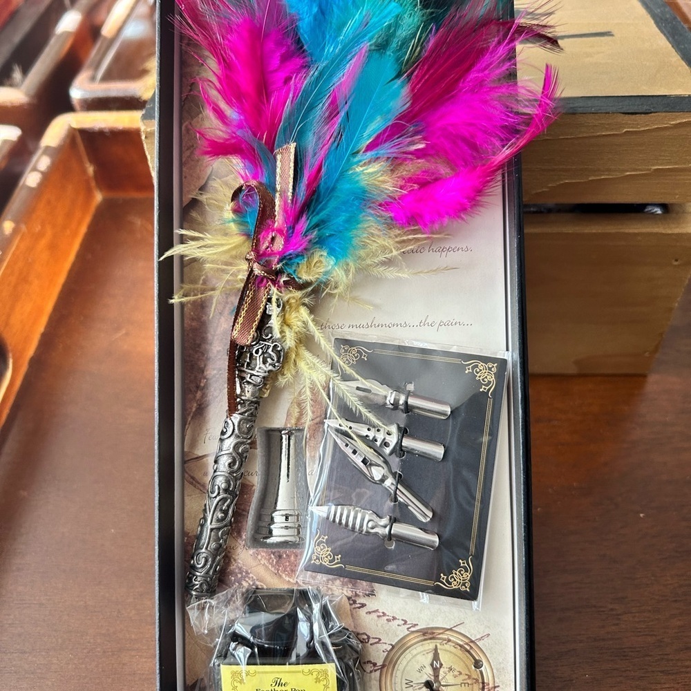 Colorful feather quill with nibs, ink and more